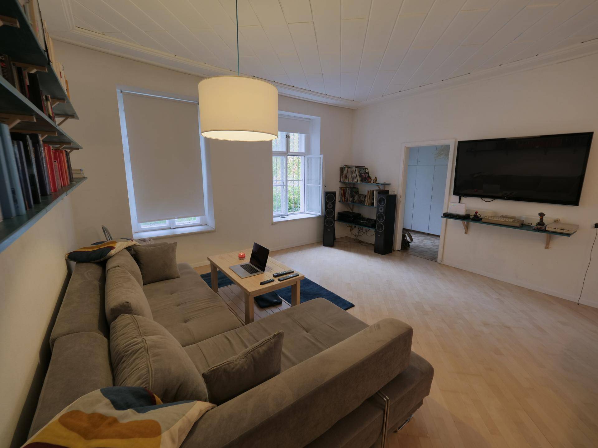 Geräumiger Wohnbereich mit bequemer Couch, Couchtisch und Unterhaltungselektronik an der Wand.