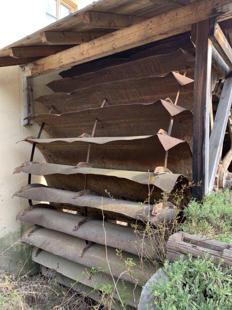 Detailaufnahme von alten, rostigen Mühlenteilen aus Metall und Holz.