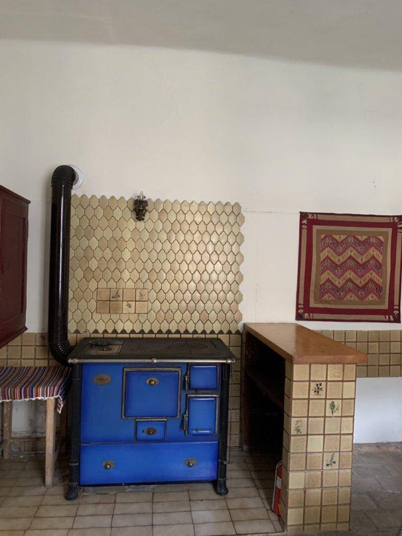 Rustikale Küche mit einem blauen Holzofen, gefliesten Arbeitsflächen und traditionellem Charme.