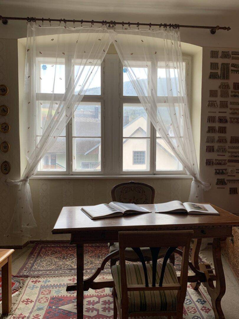 Arbeitszimmer mit Holztisch, Stuhl und Blick aus dem Fenster auf die Umgebung.
