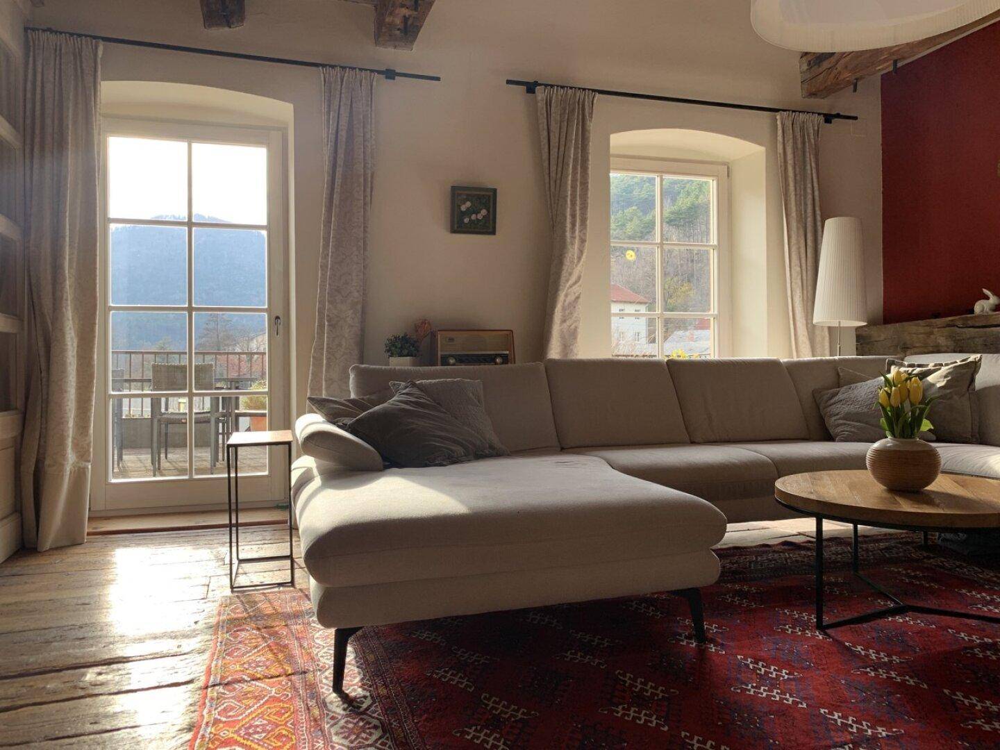 Helles Wohnzimmer mit Zugang zu einer Terrasse und Blick auf die umliegende Landschaft.