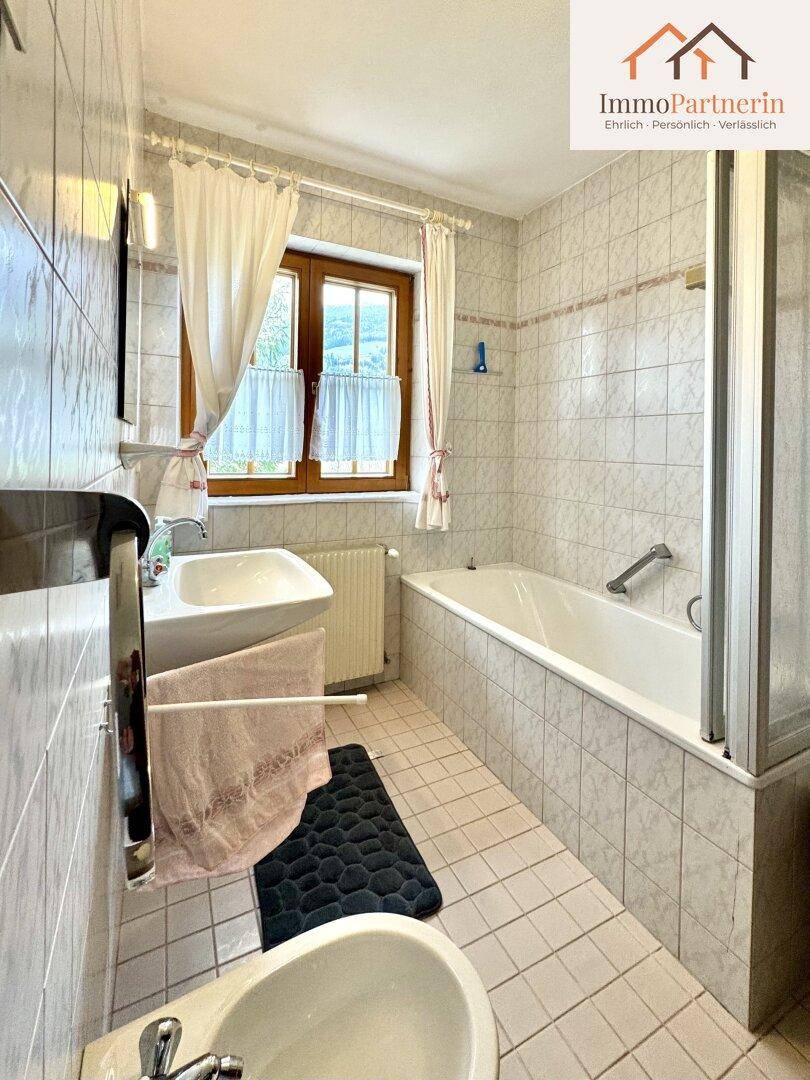Badezimmer mit Badewanne, Dusche, Bidet und einem Fenster für natürliche Belüftung.