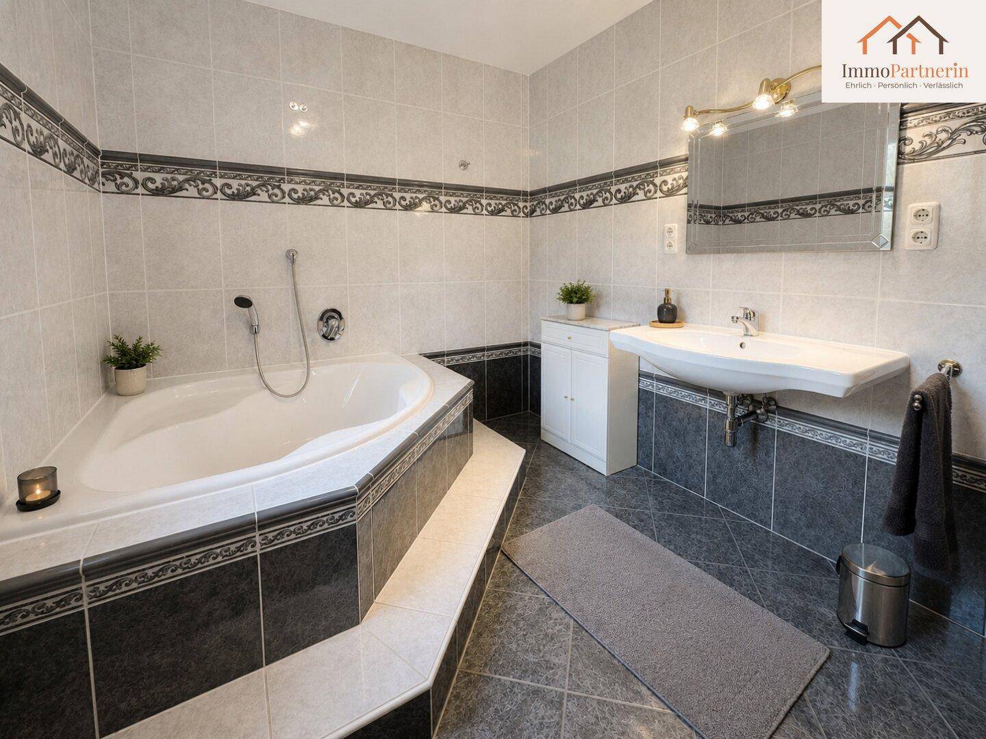 Modernes Badezimmer mit Eckbadewanne, Einzelwaschbecken und stilvollen Fliesen in Grau und Weiß.