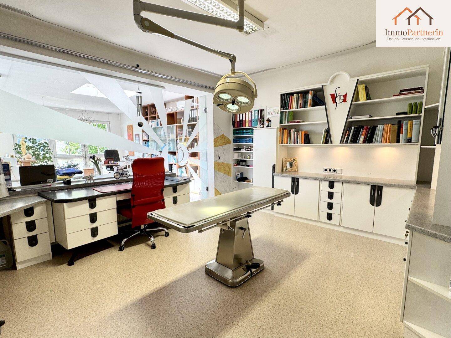 Professioneller Arbeitsraum mit Untersuchungsliege, Regalen und viel Stauraum.