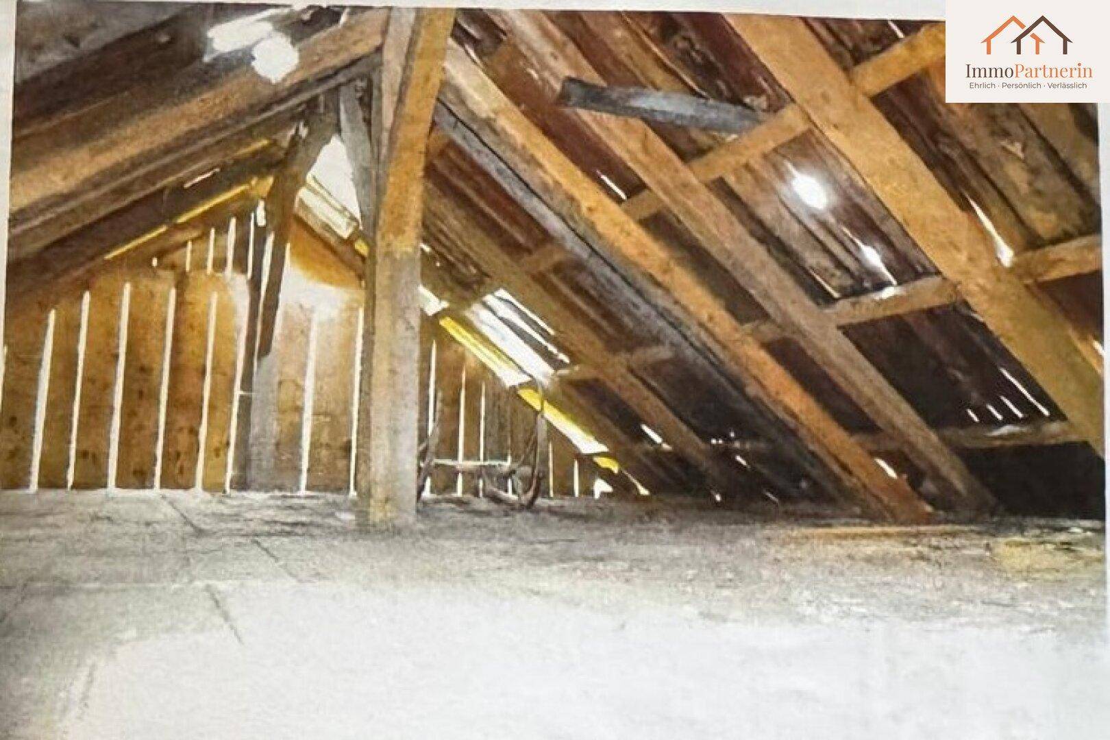 Dachboden mit sichtbaren Holzbalken und natürlichem Lichteinfall durch die Dachkonstruktion.