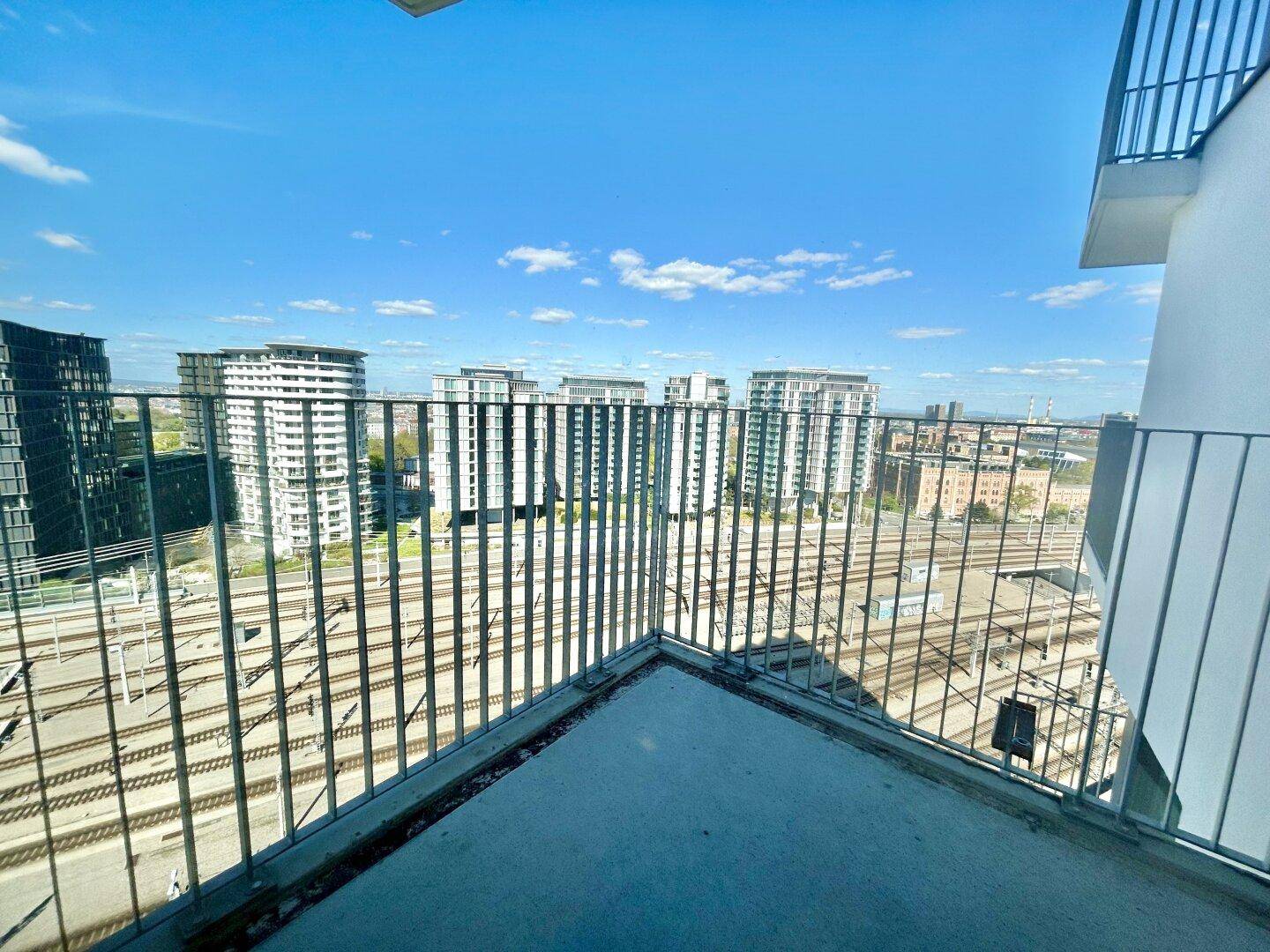 Balkon mit Blick auf die Stadtlandschaft und die darunter liegenden Bahngleise.
