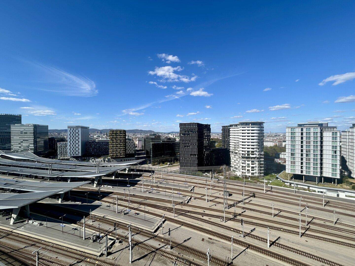 Weitläufiger Stadtblick mit modernen Gebäuden und einem großen Bahngelände.