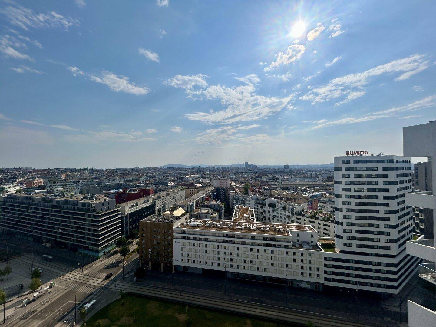 Ausgedehnter Stadtblick mit modernen Gebäuden und einer weiten Himmelslandschaft.