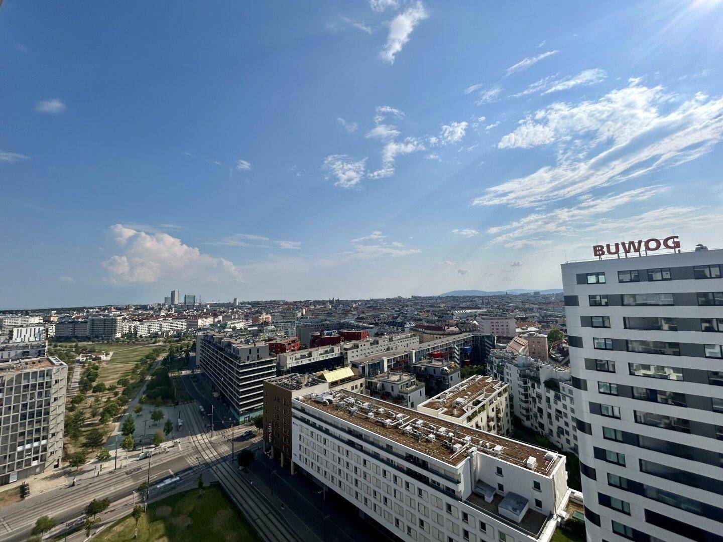 Panoramablick über die Stadt mit modernen Gebäuden unter einem klaren blauen Himmel.