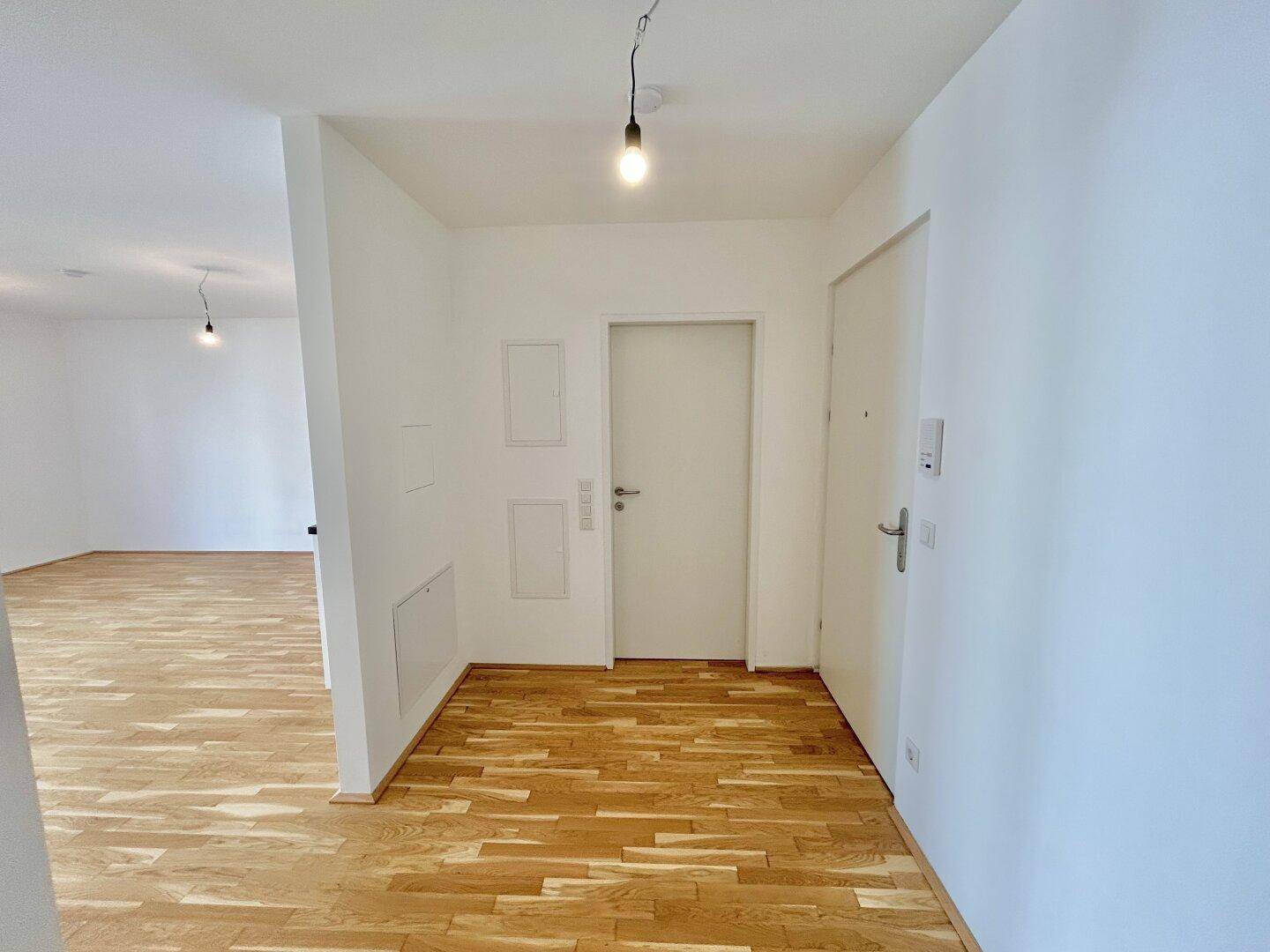 Geräumiger Flur mit Parkettboden und Zugang zu verschiedenen Zimmern der Wohnung.