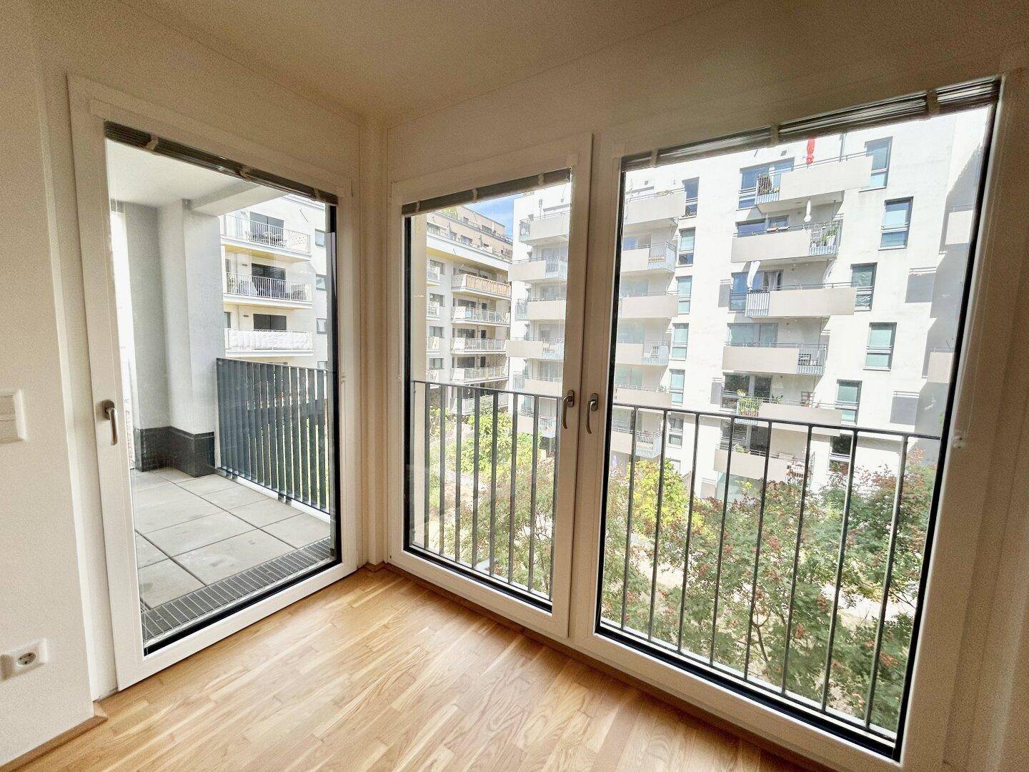Heller Wohnraum mit großen Fenstern und französischem Balkon, bietet viel Tageslicht.