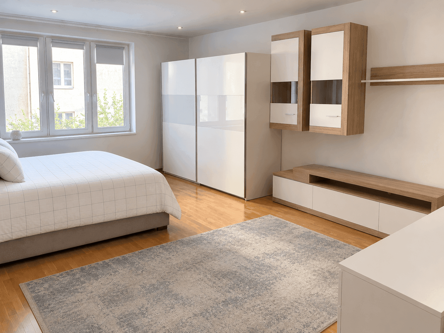 Modernes Schlafzimmer mit Holzboden, großen Fenstern und eleganten Einbauschränken.