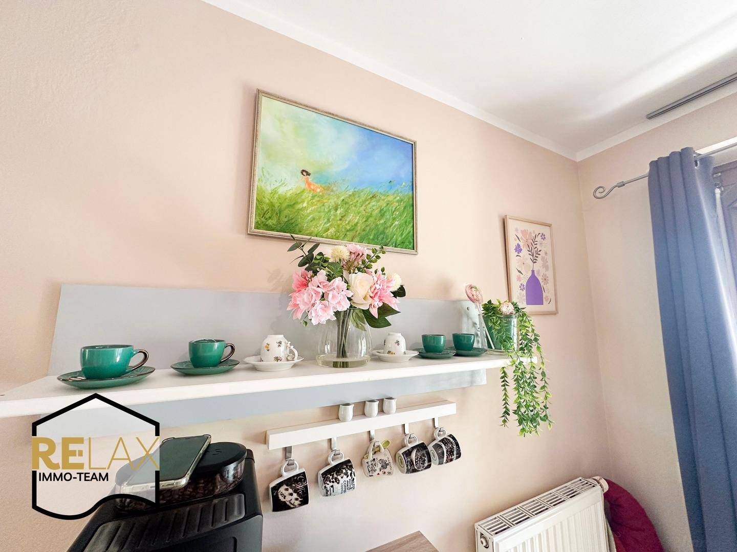 Wanddekoration mit Regal, Tassen und frischen Blumen in einem hellen Innenraum.