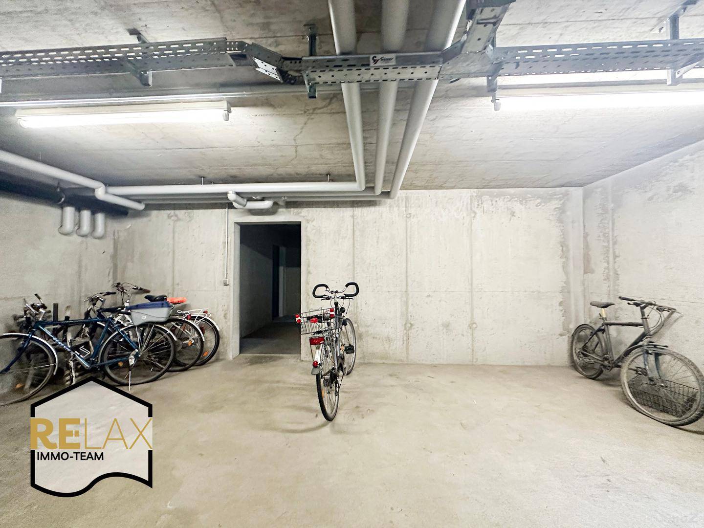 Fahrradabstellraum im Untergeschoss mit mehreren Fahrrädern und einfacher Ausstattung.