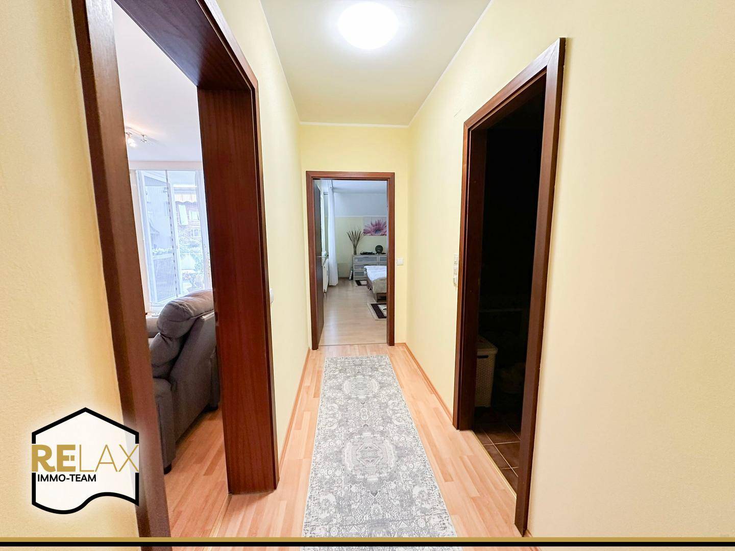 Heller Flur mit Parkettboden und Zugang zu verschiedenen Zimmern der Wohnung.