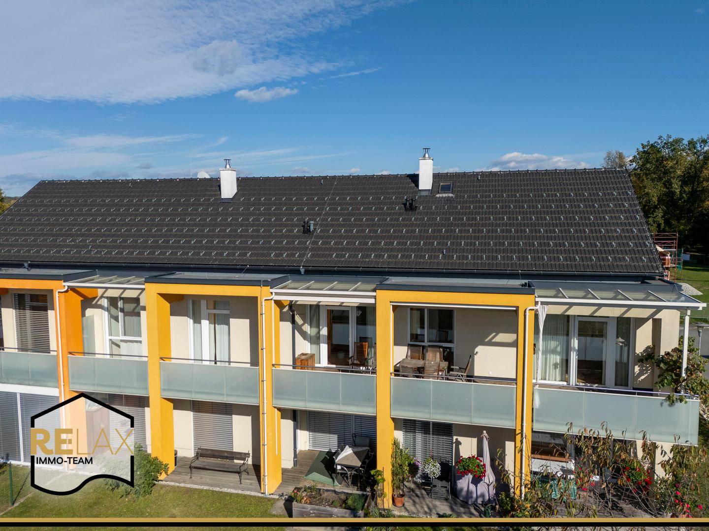 Detailansicht der modernen Fassade mit überdachten Balkonen und großen Fenstern.
