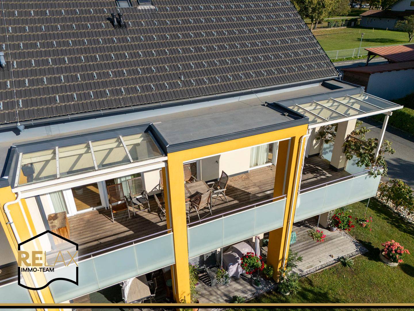 Überdachte Balkone mit Holzboden und Sitzgelegenheiten, ideal für entspannte Stunden im Freien.