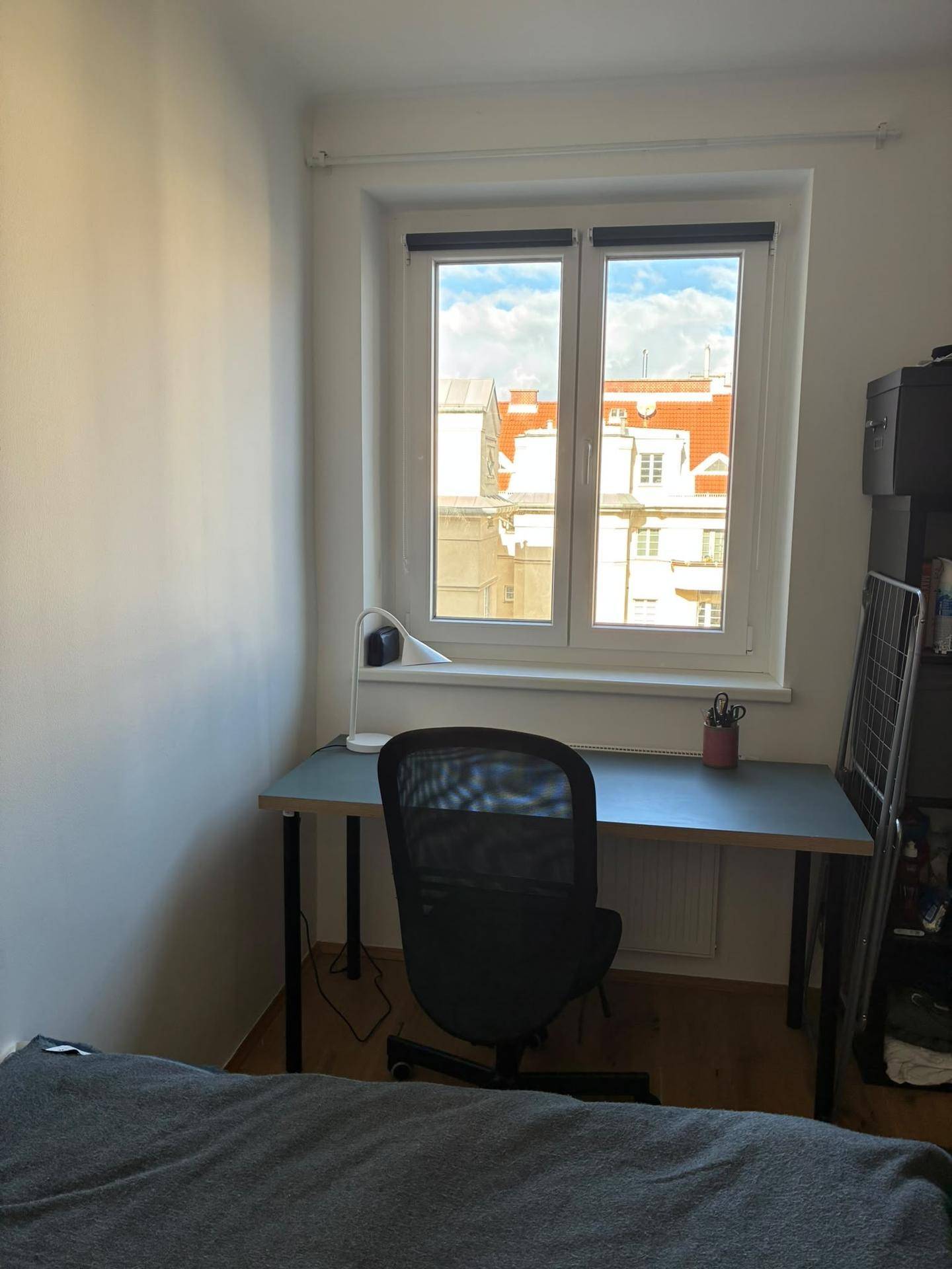 Nahaufnahme des Schreibtischs am Fenster im Schlafzimmer mit Blick auf die umliegenden Gebäude.