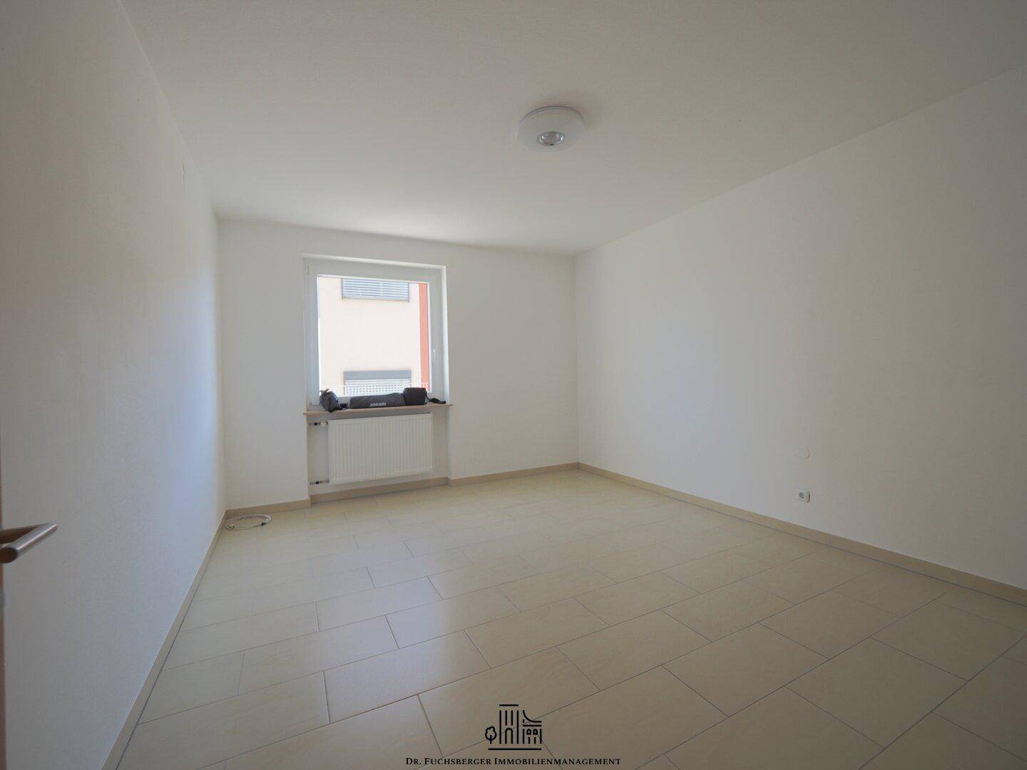 Helles Schlafzimmer mit Fliesenboden und Fenster, bietet eine ruhige und gemütliche Atmosphäre.