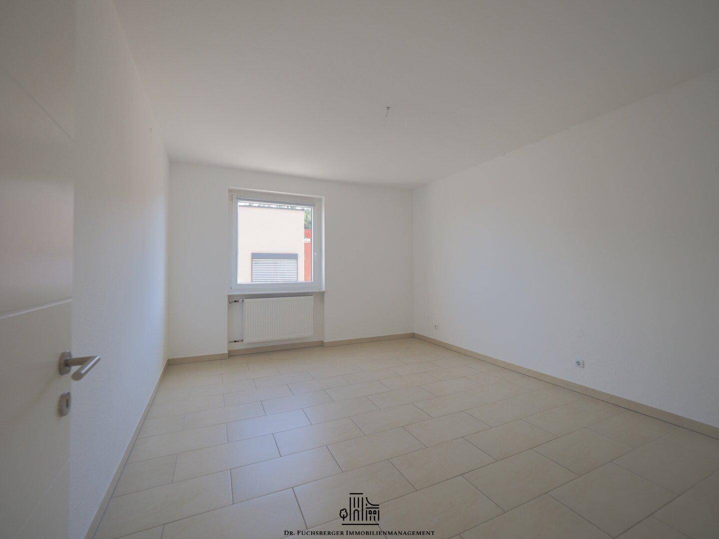 Helles Schlafzimmer mit Fliesenboden und Fenster, bietet eine ruhige und gemütliche Atmosphäre.