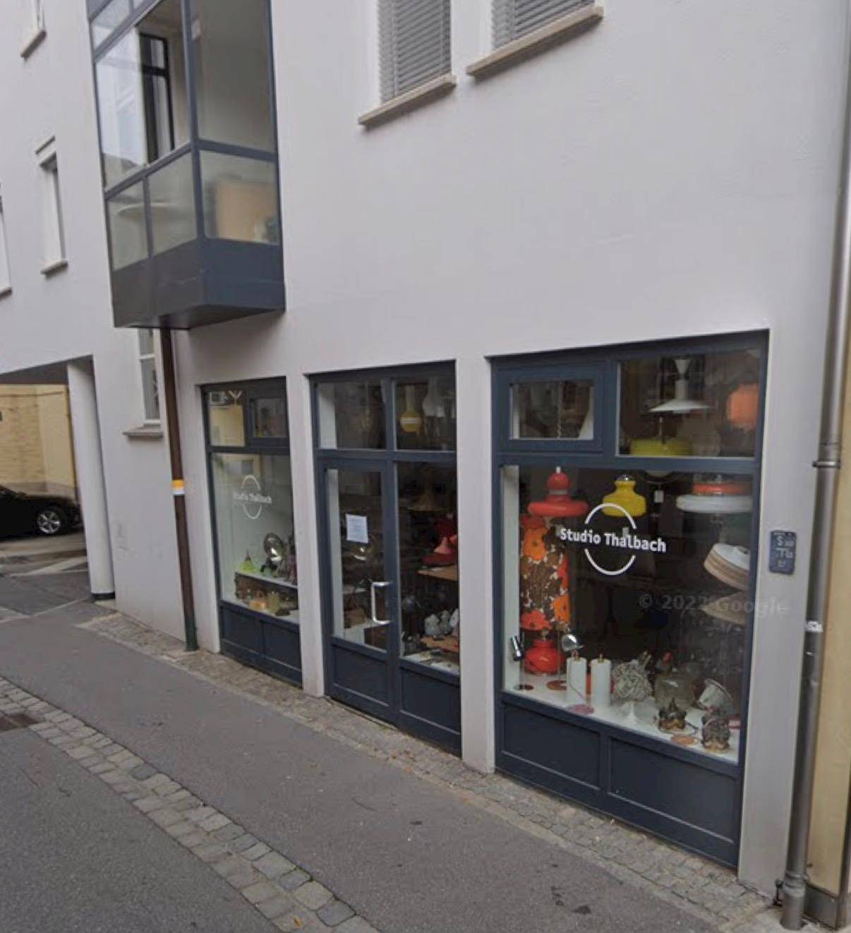 Nahaufnahme einer modernen Ladenfassade mit großen Schaufenstern und einem Erker.