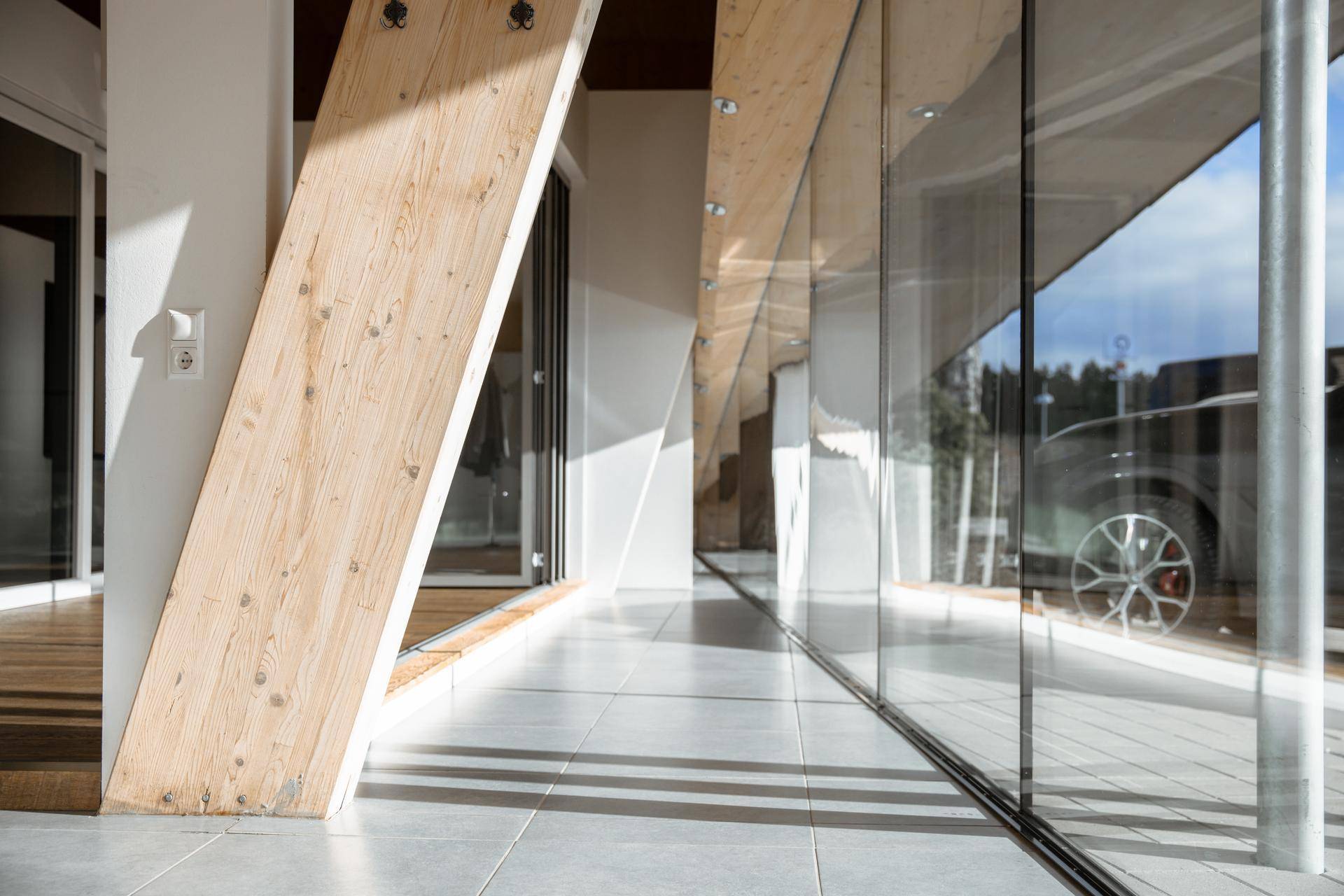 Heller Flur mit großen Glaswänden und Fliesenboden, der viel Licht und eine moderne Ästhetik bietet.