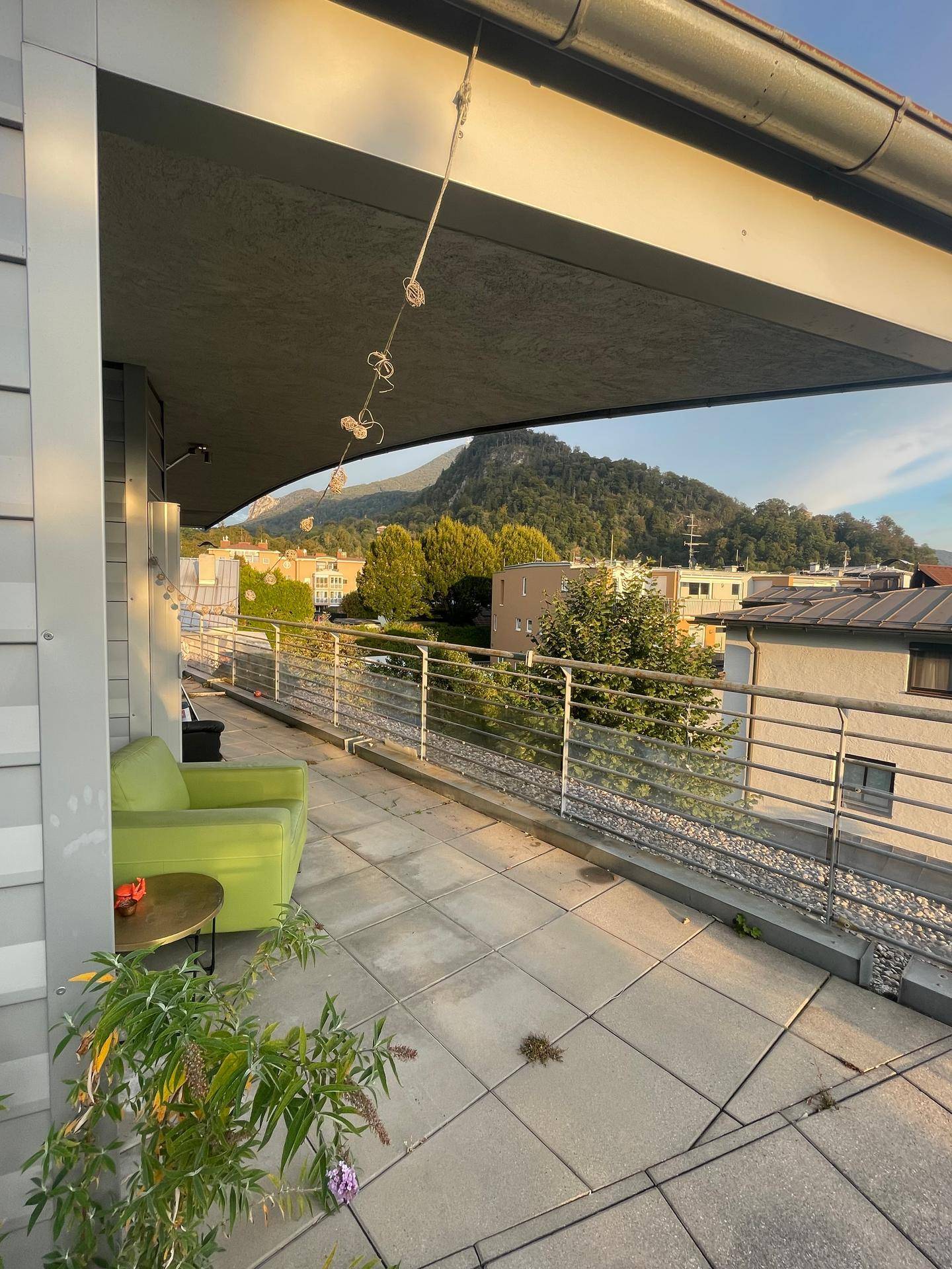 Überdachter Balkon mit bequemen Sitzgelegenheiten und beeindruckendem Bergblick.