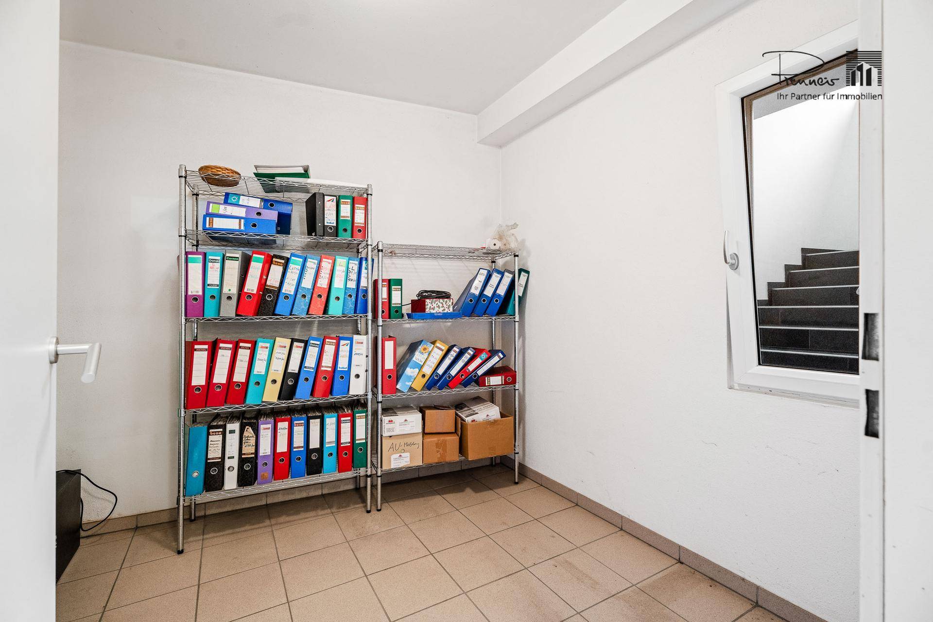Praktischer Abstellraum mit Regalen voller Aktenordner und einem kleinen Fenster, das für Belüftung sorgt.