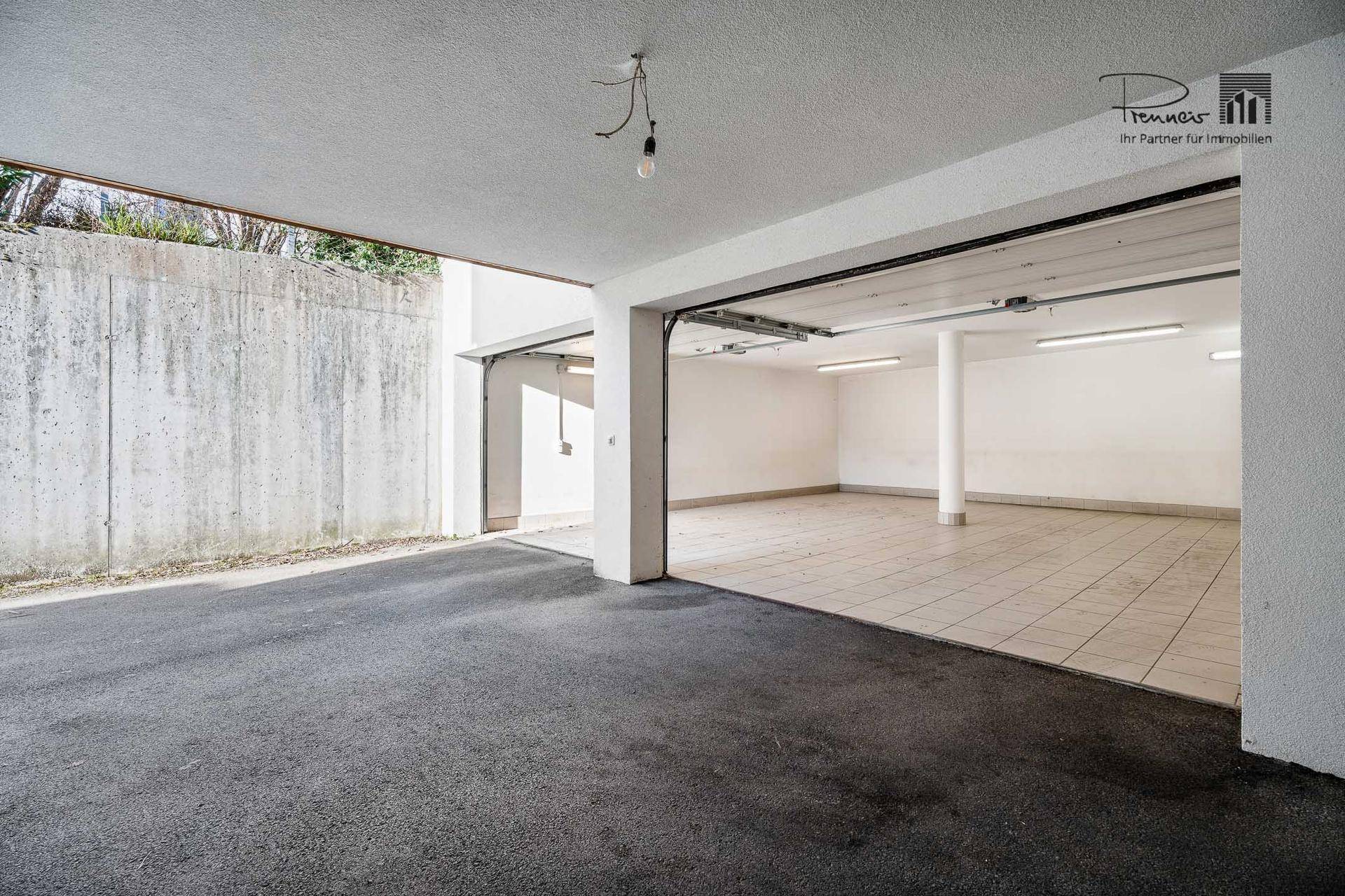 Geräumige Garageneinfahrt mit Zugang zu einer Tiefgarage, die viel Platz für Fahrzeuge bietet.