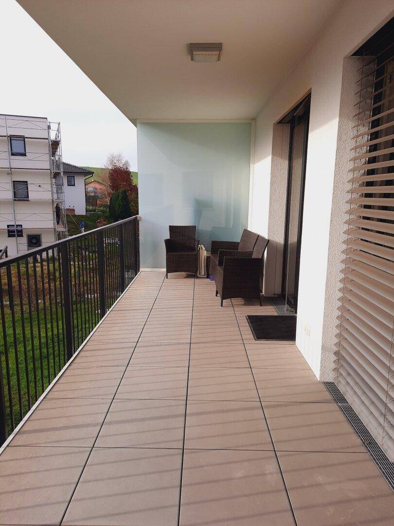 Großer Balkon mit Sitzgelegenheiten und seitlichem Sichtschutz, ideal zum Entspannen im Freien.