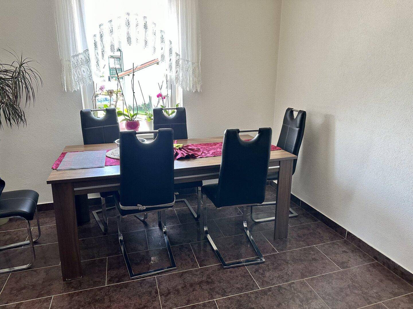 Essbereich mit Holztisch und modernen Stühlen, ideal für gemeinsame Mahlzeiten.