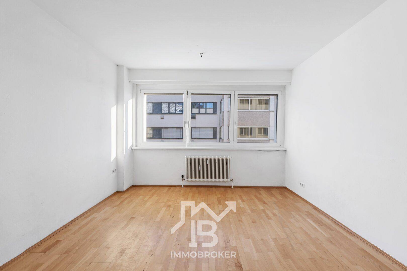 Geräumiges Zimmer mit Parkettboden und breitem Fenster, ideal für individuelle Gestaltung.
