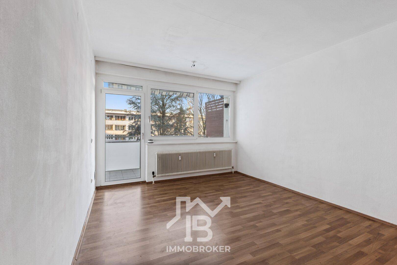Geräumiges Zimmer mit Laminatboden und Balkonzugang, ideal für helle Wohnkonzepte.