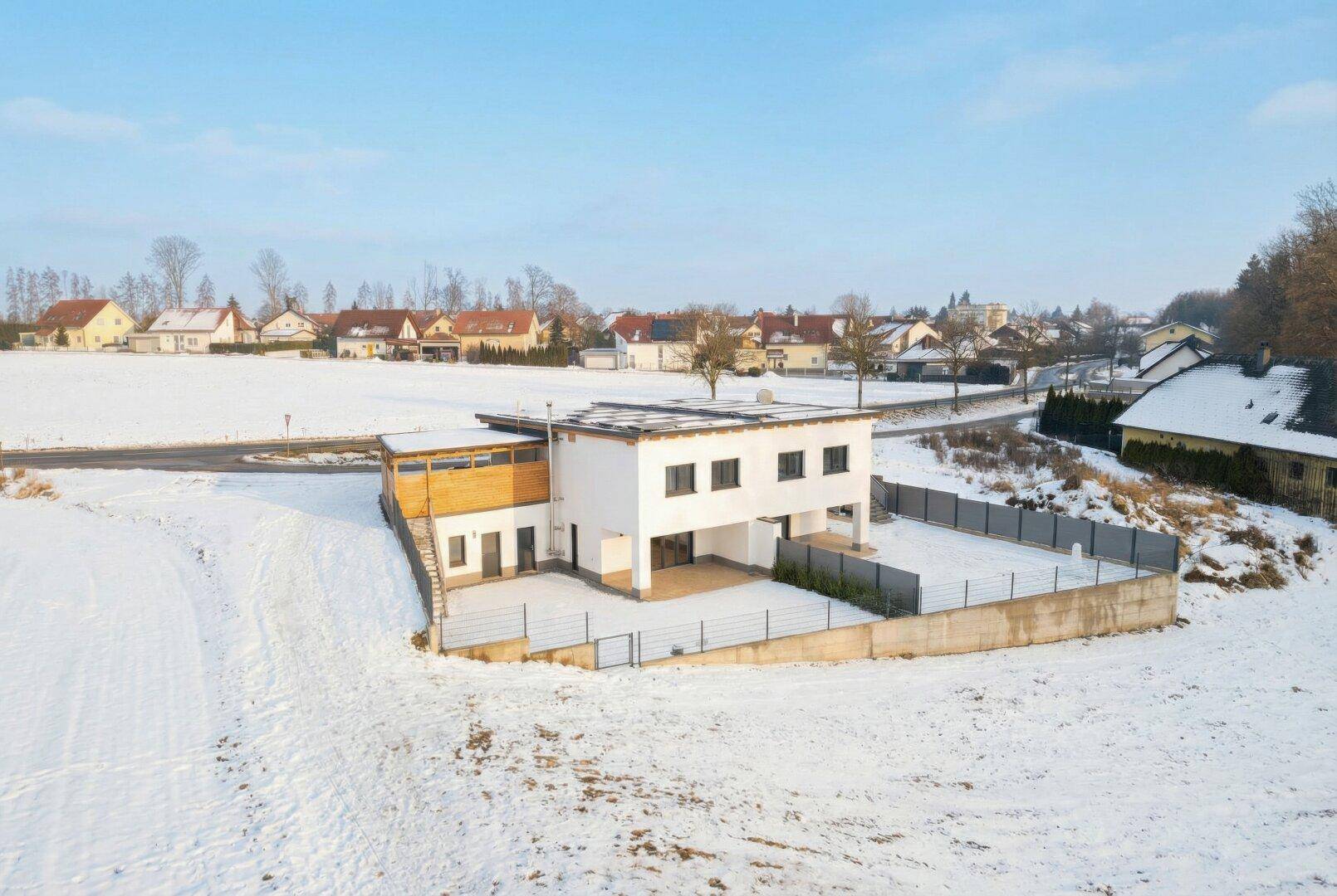 Luftaufnahme des Anwesens mit umliegenden Häusern, Feldern und verschneiter Landschaft.