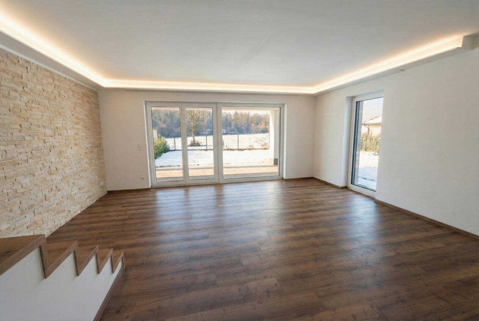 Helles Wohnzimmer mit Holzboden, Steinwand und großen Schiebetüren zum verschneiten Garten.