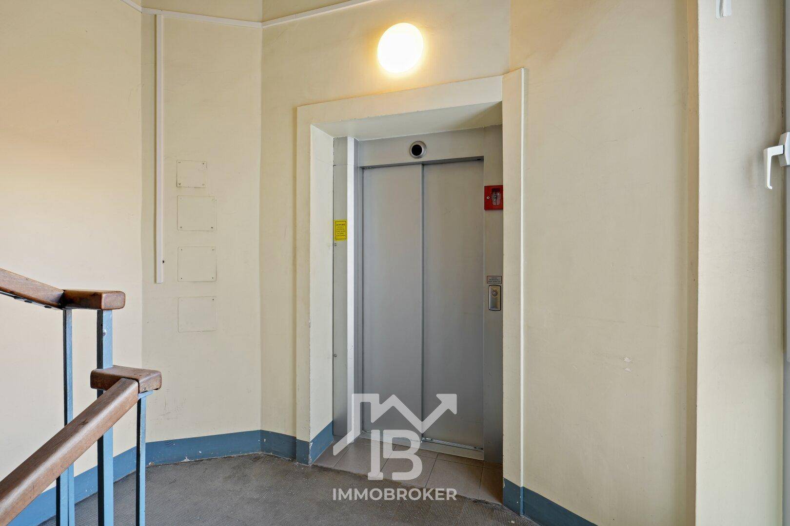 Treppenhaus-Podest mit einem modernen Aufzug, bietet bequemen Zugang zu den verschiedenen Etagen.