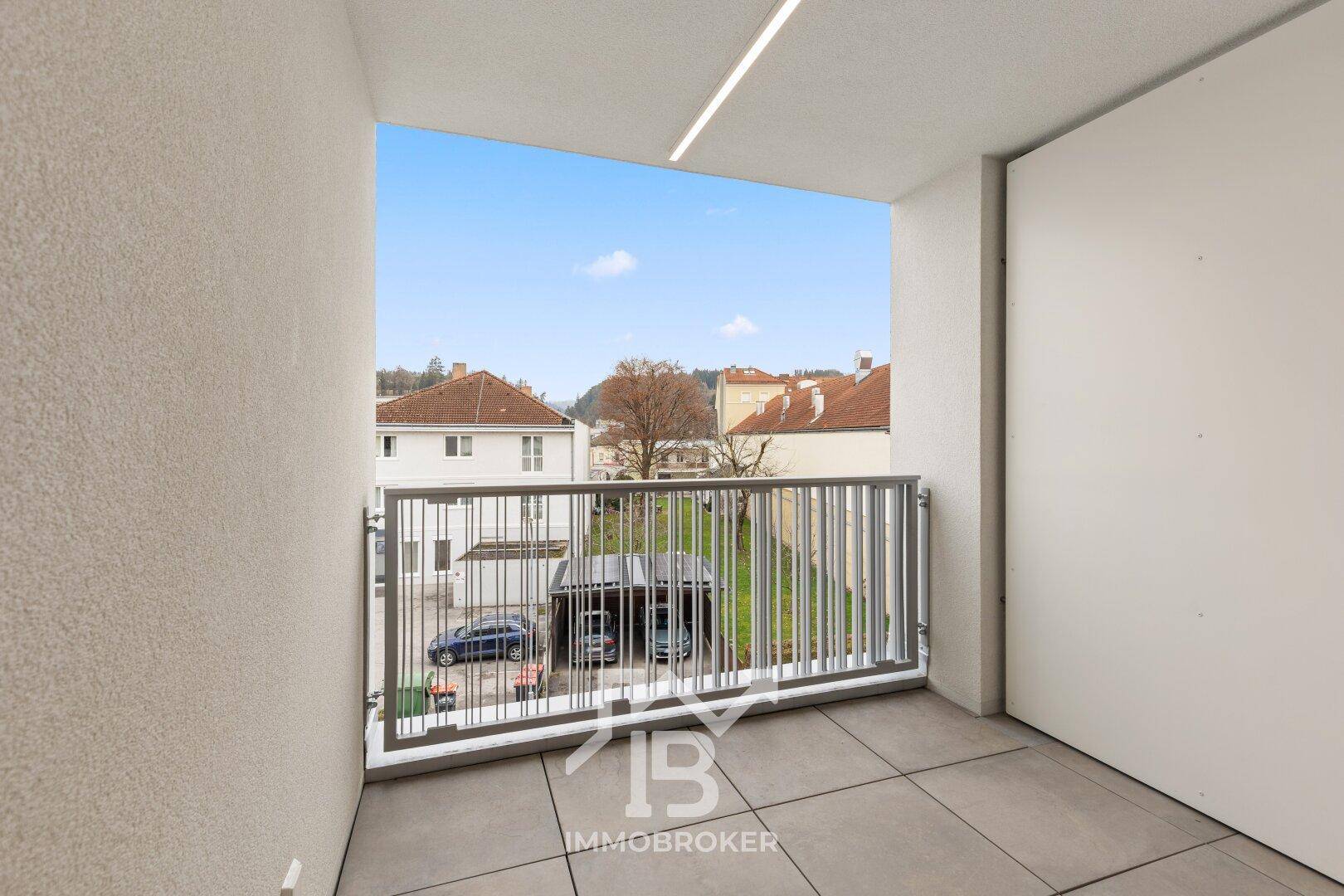 Geräumiger Balkon mit Fliesenboden und Blick auf die umliegende Wohngegend.