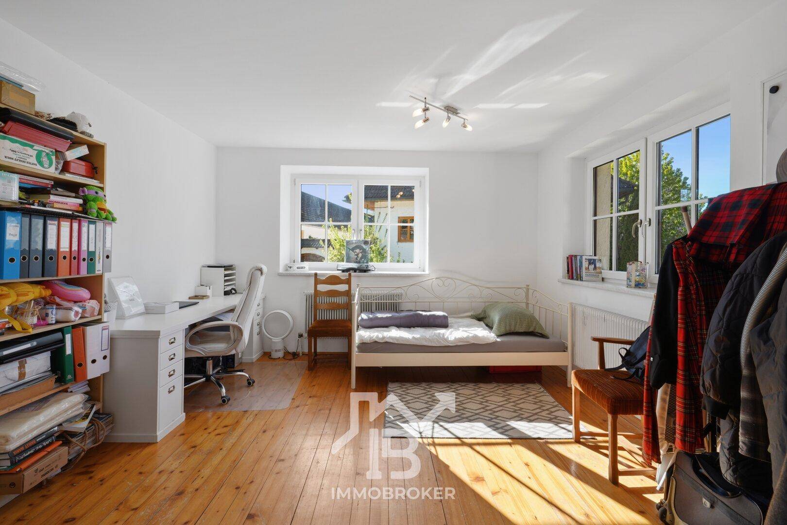 Helles Schlafzimmer mit Holzboden, Einzelbett und Schreibtisch, ideal als Gäste- oder Arbeitszimmer.