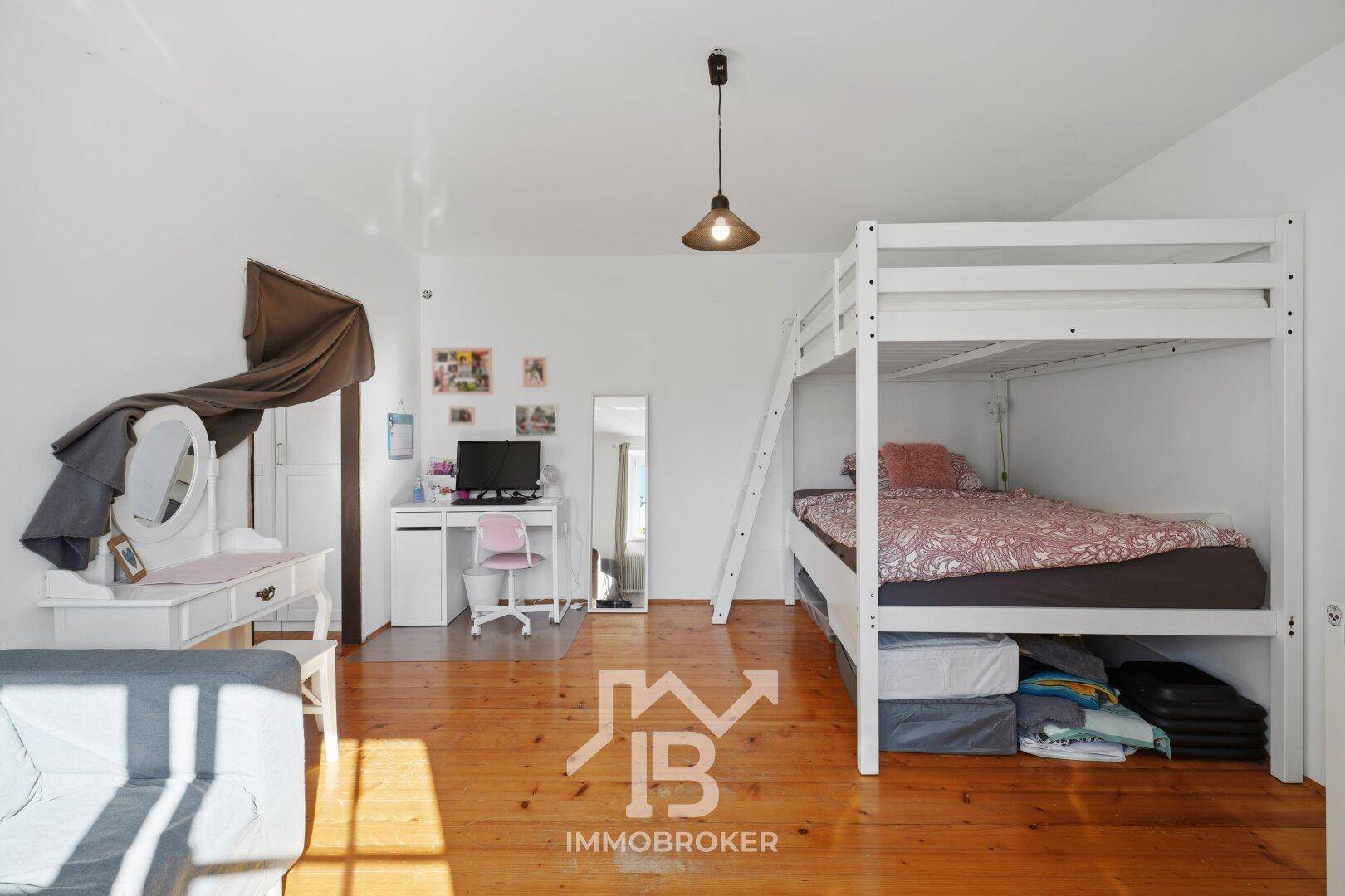 Geräumiges Kinderzimmer mit Etagenbett, Schreibtisch und Spielbereich, hell und funktional eingerichtet.
