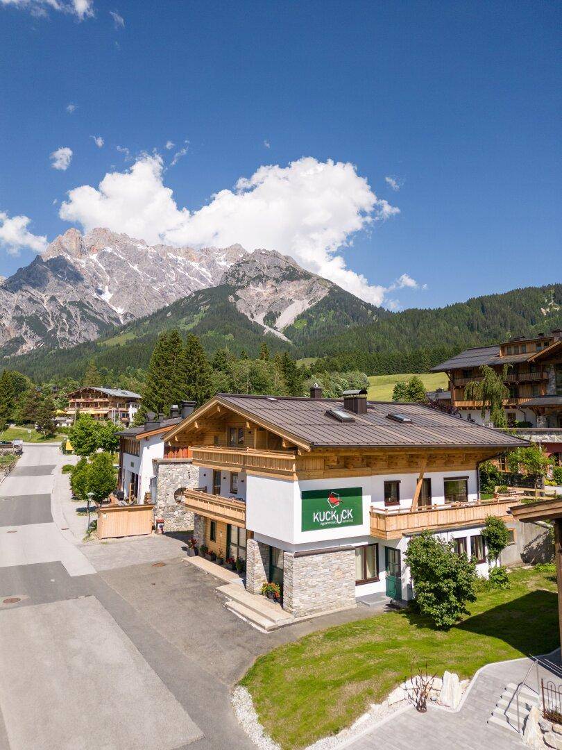 Idyllisches Alpenhaus mit Holzelementen und weitem Blick auf die umliegende Berglandschaft.