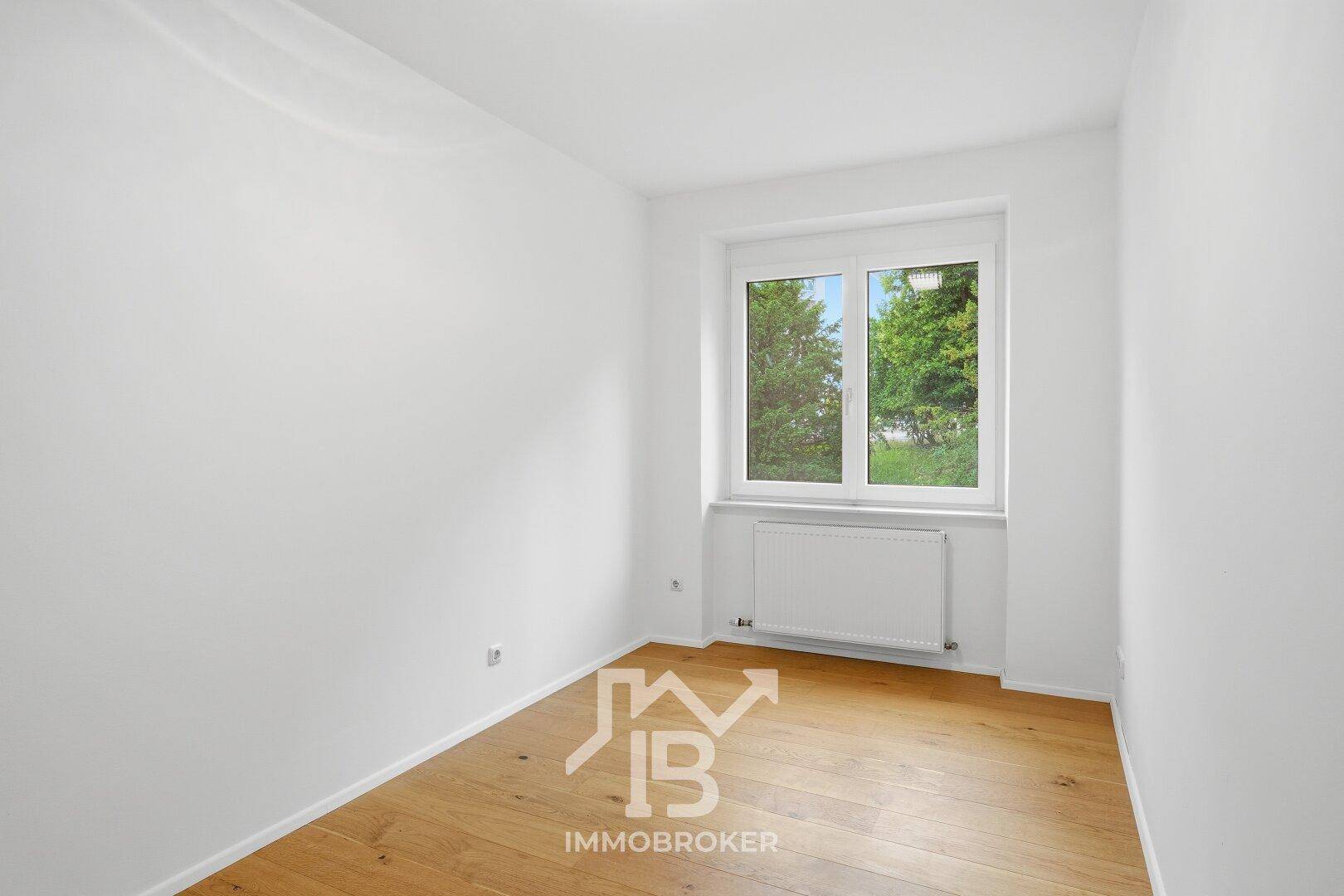 Gemütliches Zimmer mit Parkettboden und Fenster, das viel natürliches Licht hereinlässt.