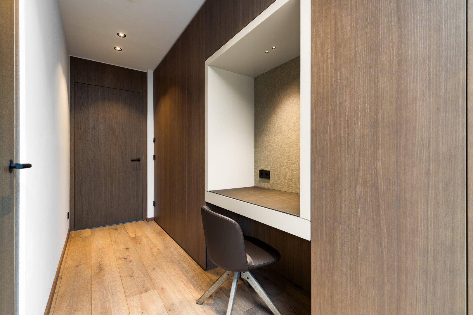 Funktionaler Flur mit integriertem Schreibtischbereich und Holzboden, ideal für Home-Office.