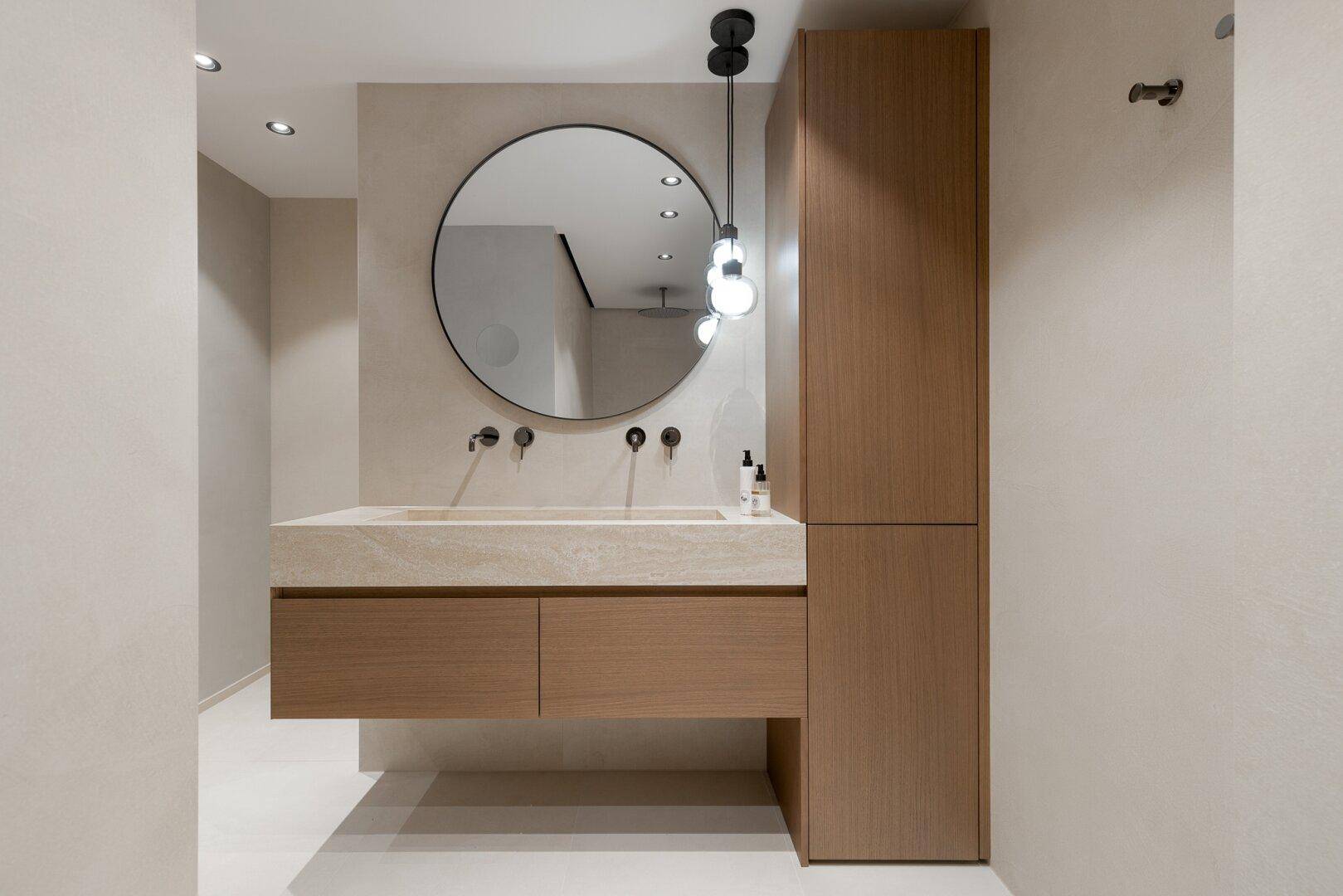 Elegantes Badezimmer mit Doppelwaschtisch, großem Spiegel und integriertem Hochschrank für Stauraum.