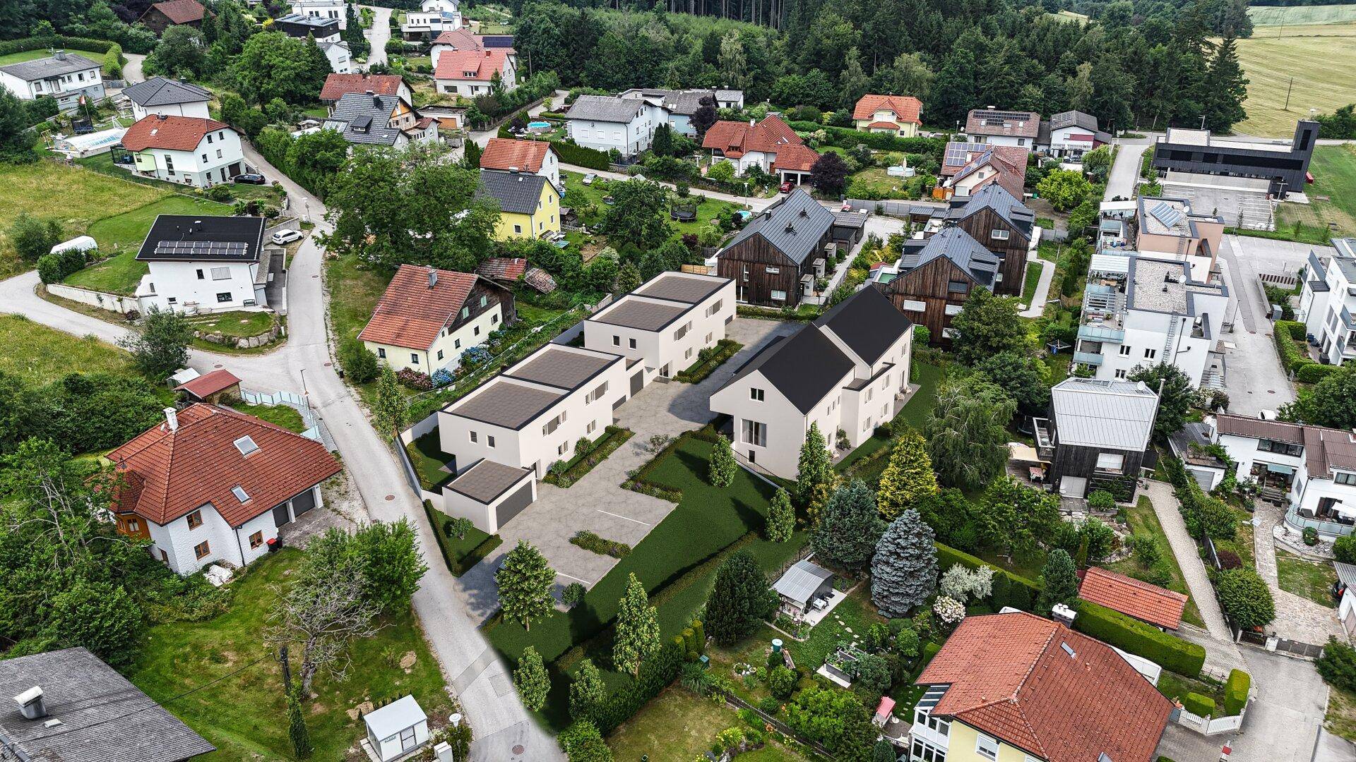 Luftaufnahme einer neuen Wohnsiedlung mit modernen Häusern in grüner Umgebung.