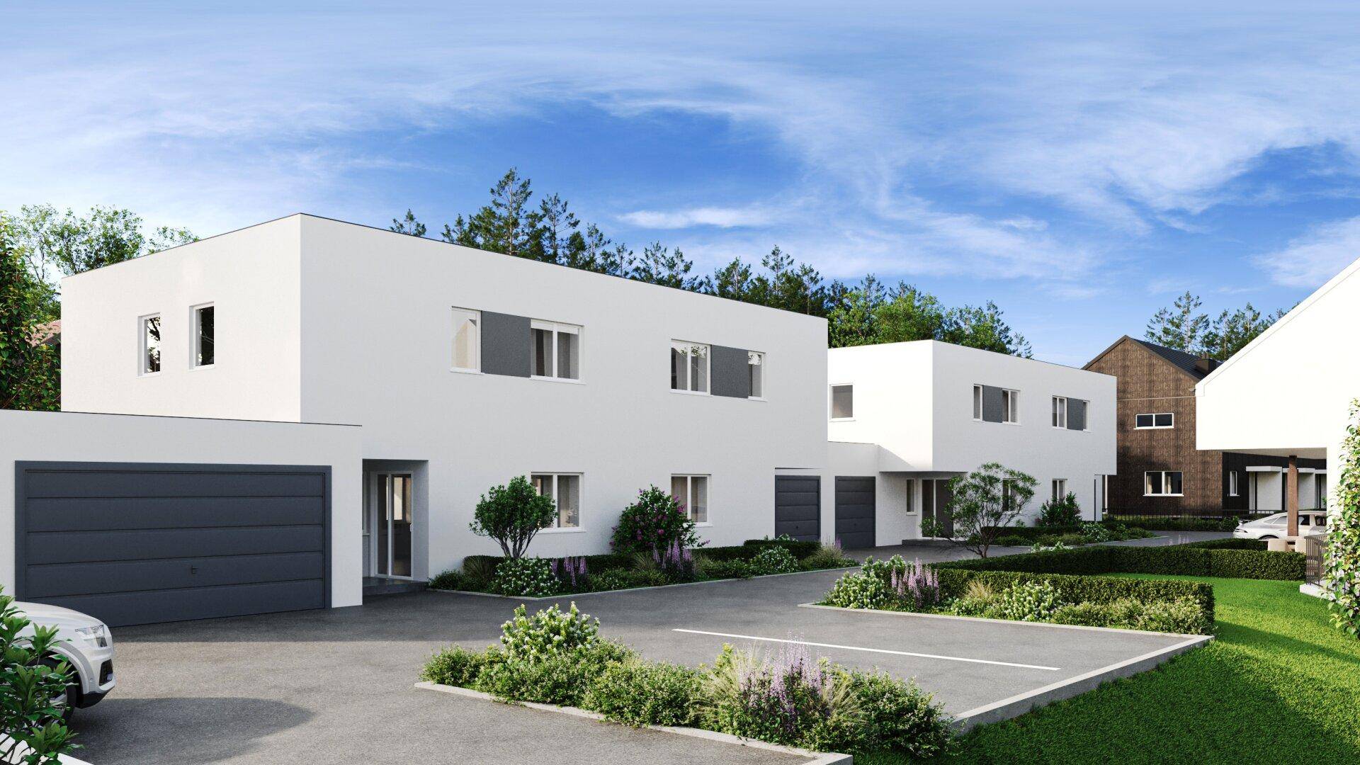 Reihenhäuser mit moderner Architektur, Garagen und Außenparkplätzen unter blauem Himmel.