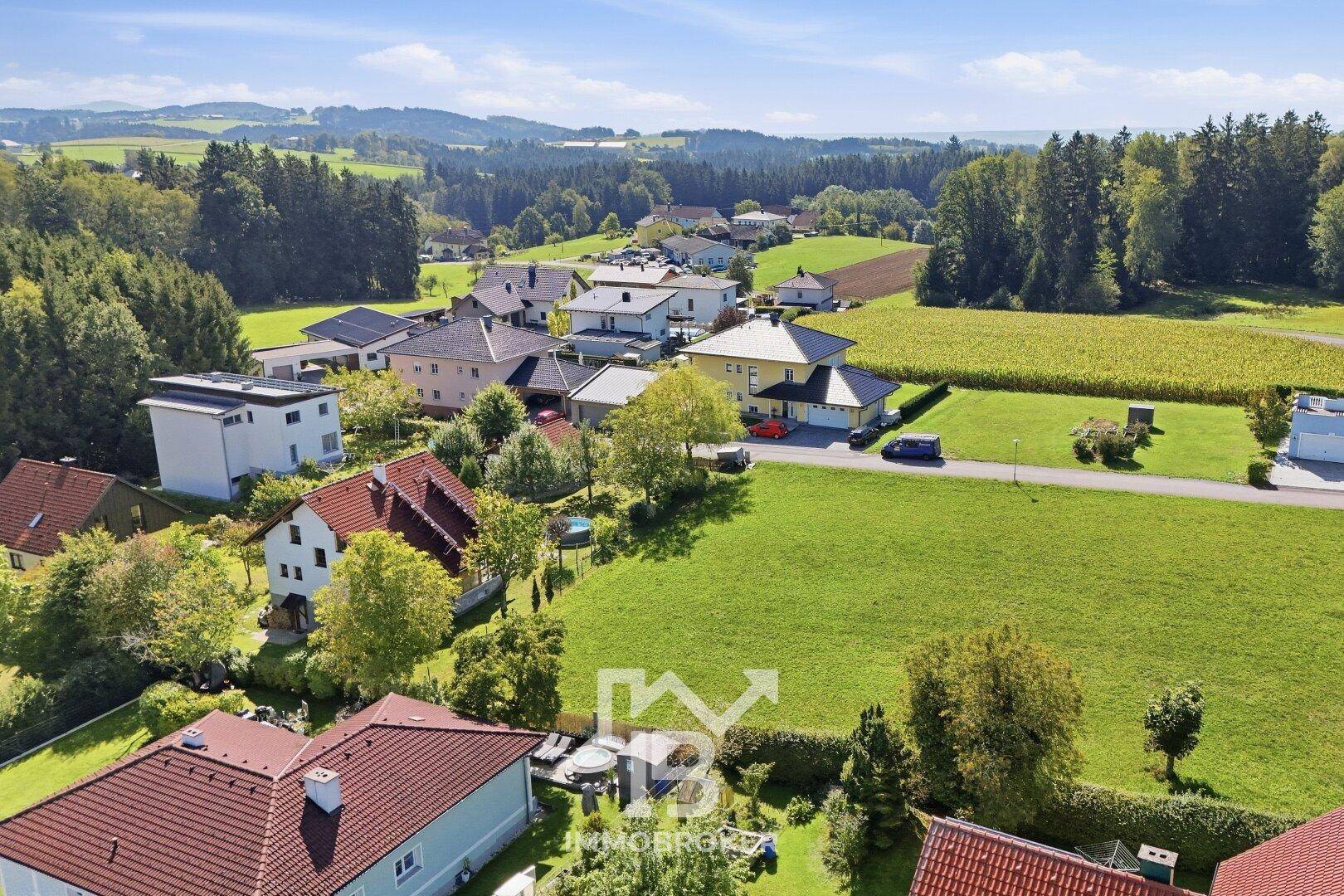 Panoramablick über die ländliche Wohngegend mit weitläufigen Grünflächen und angrenzenden Feldern.