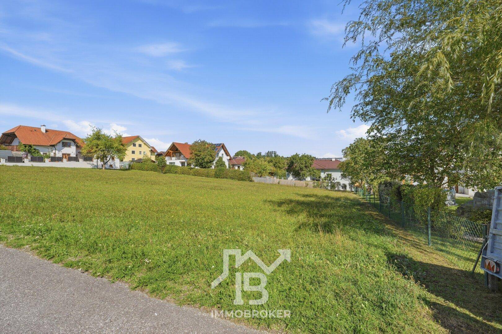Weitläufige grüne Wiese mit Blick auf die umliegende Bebauung und die natürliche Landschaft.