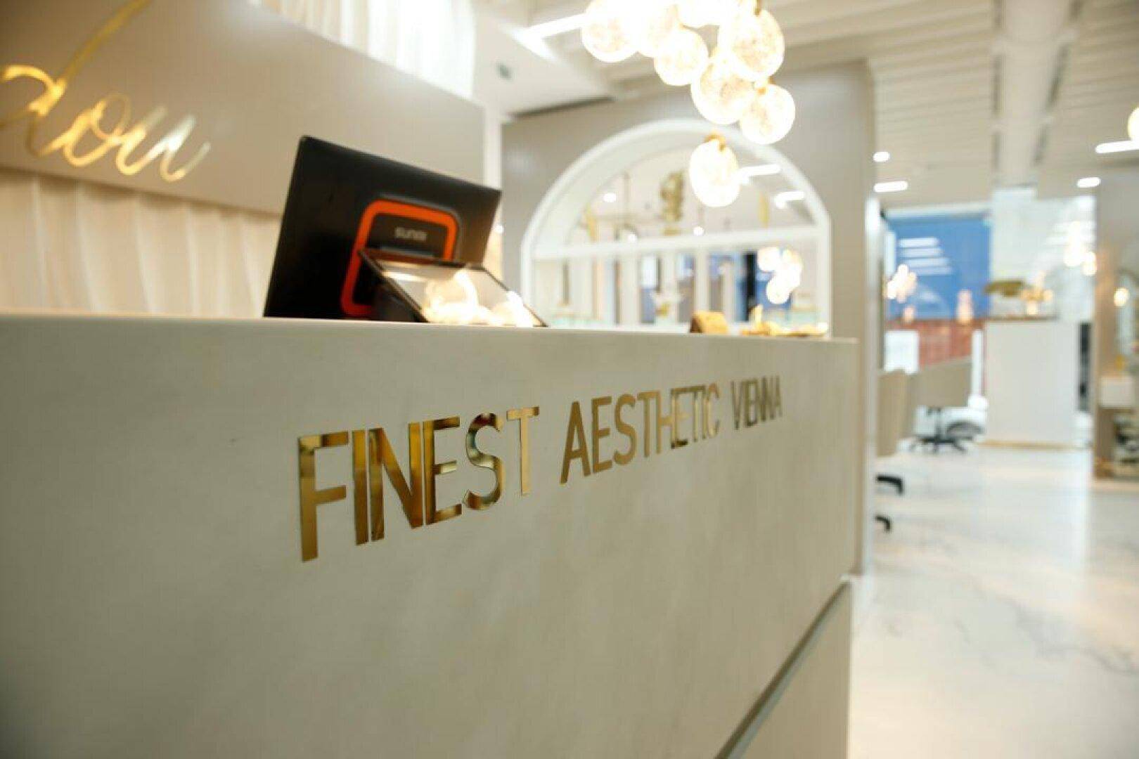 Empfangsbereich mit einer modernen Theke und goldenen Schriftzügen, die den Namen des Geschäfts hervorheben.