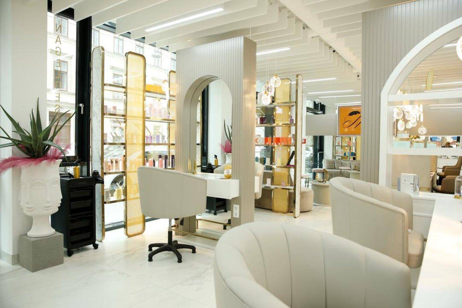 Geräumiger und heller Salonbereich mit modernen Behandlungsstühlen, großen Fenstern und stilvoller Dekoration.