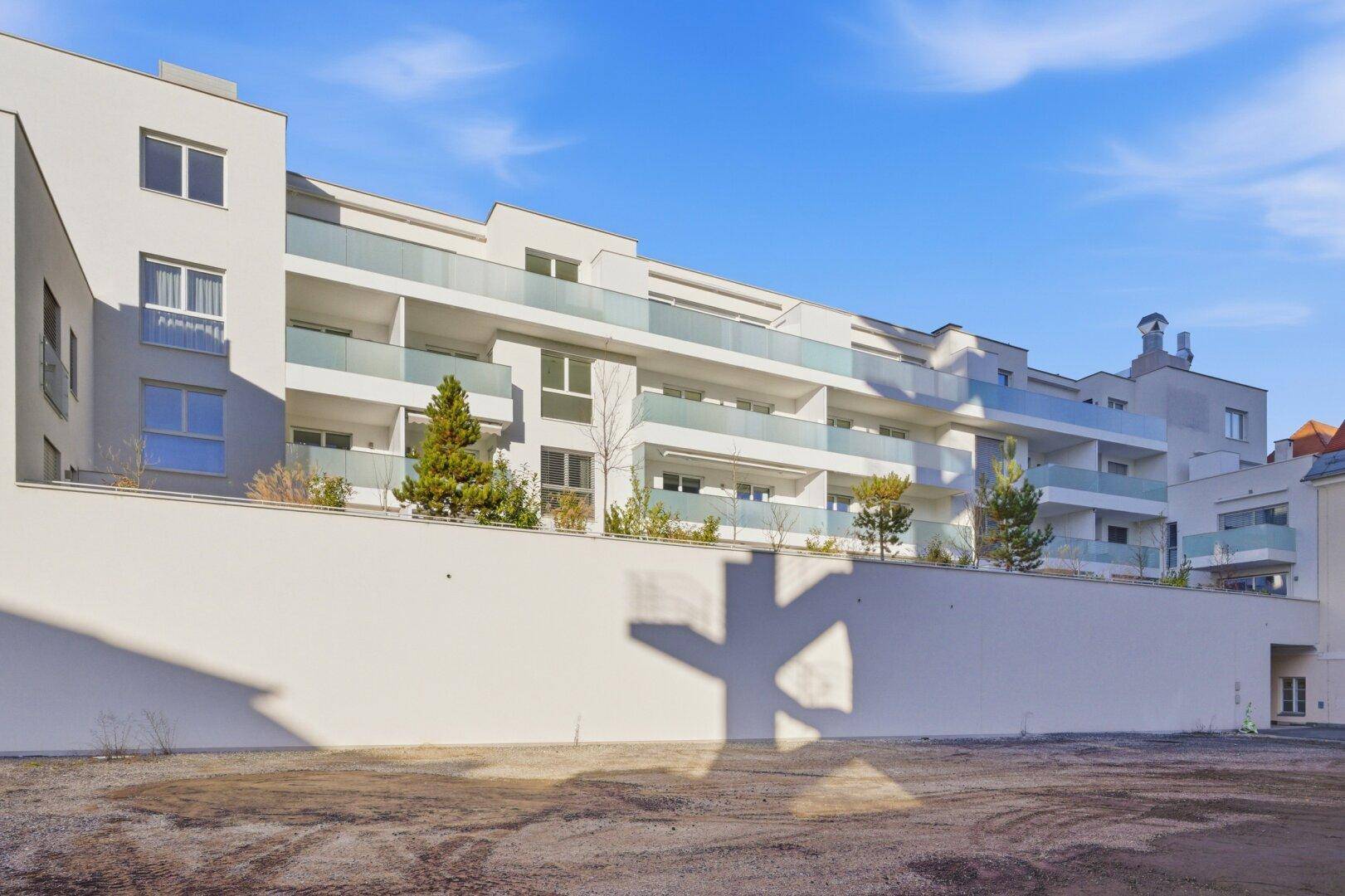 Neubau-Wohngebäude mit mehreren Etagen, Balkonen und einer klaren, modernen Architektur.